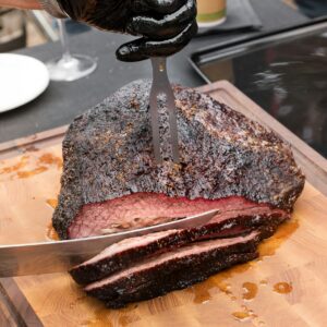 Chef carving a portion of succulent beef brisket