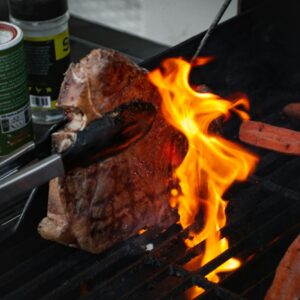 Closeup shot of grilling a T-bone with jalapeno and carrots