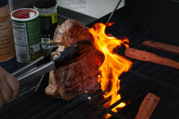 Closeup shot of grilling a T-bone with jalapeno and carrots